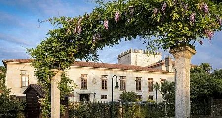 Entrada de un pazo gallego con arcos rodeados de flores._314