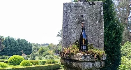 Historical fountain with a wine bottle in a garden._199