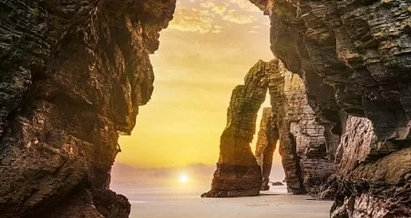 Natural arch at the Playa de las Catedrales at sunrise._156